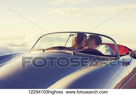 Romantic Young Attractive Couple Watching The Sunset And Kissing In Classic Vintage Sports Car View Large Photo Image Stock Photograph - Romantic Young Attractive Couple Watching The Sunset And Kissing In Classic Vintage Sports Car. Fotosearch