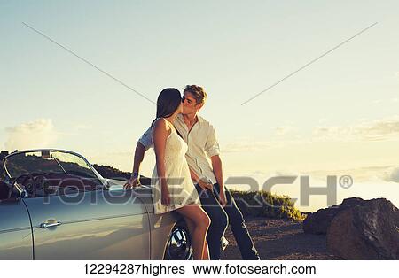 Romantic Young Attractive Couple Watching The Sunset And Kissing With Classic Vintage Sports Car View Large Photo Image Stock Photograph - Romantic Young Attractive Couple Watching The Sunset And Kissing With Classic Vintage Sports Car. Fotosearch