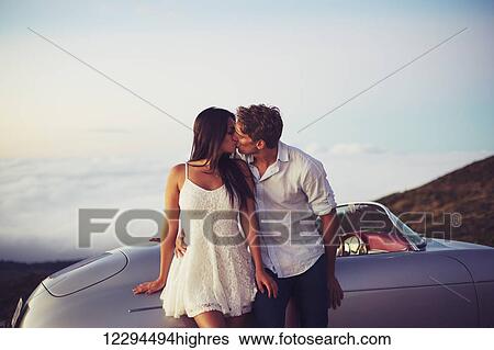 Romantic Young Attractive Couple Watching The Sunset And Kissing With Classic Vintage Sports Car View Large Photo Image Stock Photograph - Romantic Young Attractive Couple Watching The Sunset And Kissing With Classic Vintage Sports Car. Fotosearch