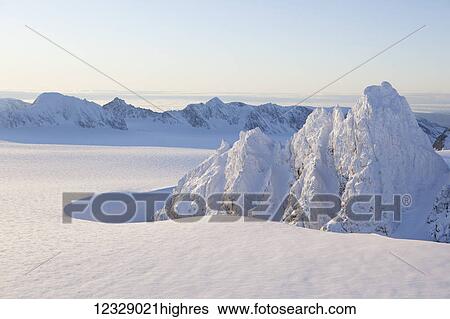 Stock Photograph - Rugged Kenai mountain peaks covered in snow against a blue sky, Kachemak Bay State Park; Alaska, United States of America. Fotosearch