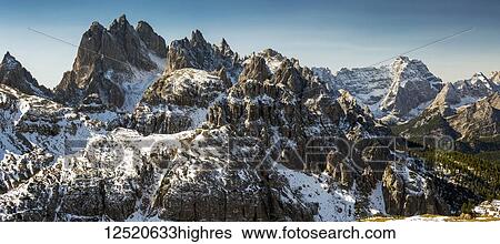 Stock Photograph - Rugged snow-covered mountain range with blue sky; San Candido, Bolzano, Italy. Fotosearch