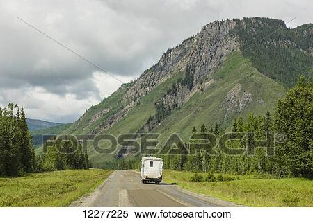 Stock Photography - RV camper drives down the Alaska Highway, west of Fort Nelson, British Columbia Canada, Summer. Fotosearch
