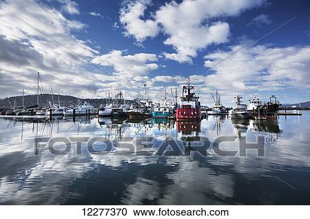 Stock Image - Scenic view of clouds and fishing boats reflecting in Bellingham Harbor, Washington, USA. Fotosearch