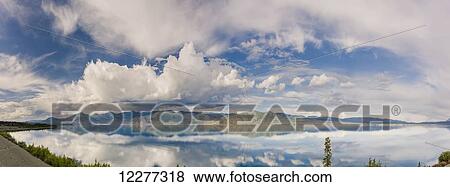 Stock Photo - Scenic view of mountains and clouds reflecting in the calm waters of Kluane Lake, Yukon Territory, Canada, Summer. Fotosearch