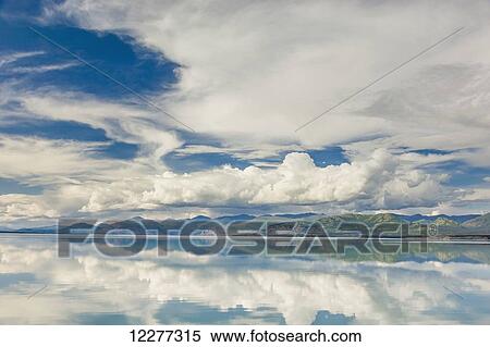Stock Photography - Scenic view of mountains and clouds reflecting in the calm waters of Kluane Lake, Yukon Territory, Canada, Summer. Fotosearch