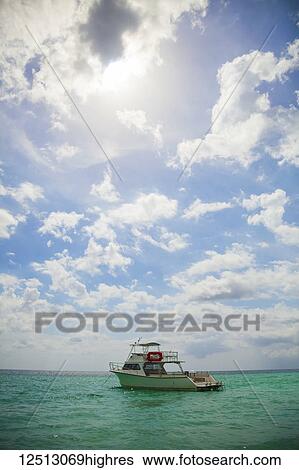 Stock Photograph - Scuba dive boat under open sky on tropical water; Negril, Jamaica. Fotosearch