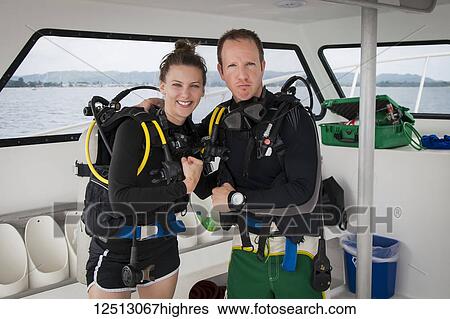 Stock Photograph - Scuba divers aboard a boat, posing for the camera; Negril, Jamaica. Fotosearch