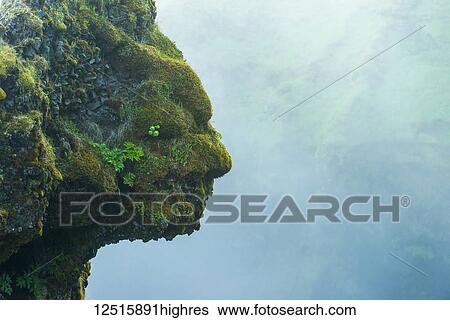 Stock Photograph - Shape of head and face in natural rocks beside Skogafoss waterfall, Iceland. Fotosearch