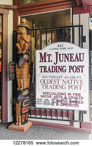 Stock Photography - Sign and totem pole at the entrance to the Mt. Juneau Trading Post; Southeast Alaska's oldest trading post in native art. Fotosearch