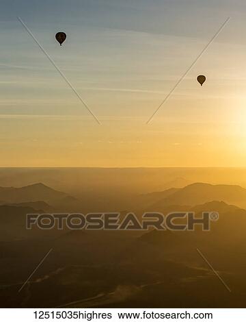 Silhouette of hot air balloons in the golden sky over the sand dunes at sunrise in the Namib Desert; Sossusvlei, Hardap Region, Namibia View Large Photo Image Stock Photograph - Silhouette of hot air balloons in the golden sky over the sand dunes at sunrise in the Namib Desert; Sossusvlei, Hardap Region, Namibia. Fotosearch