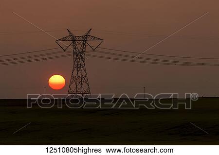 Silhouette of large metal electrical tower with power lines and orange sun ball; Blackie, Alberta, Canada View Large Photo Image Stock Photograph - Silhouette of large metal electrical tower with power lines and orange sun ball; Blackie, Alberta, Canada. Fotosearch
