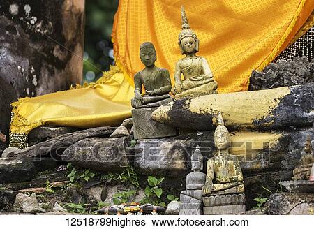 Stock Photograph - Small buddha statues in the ruins of Wat Piawat temple, destroyed in the Indochina War; Muang Khoun, Xiangkhouang, Laos. Fotosearch