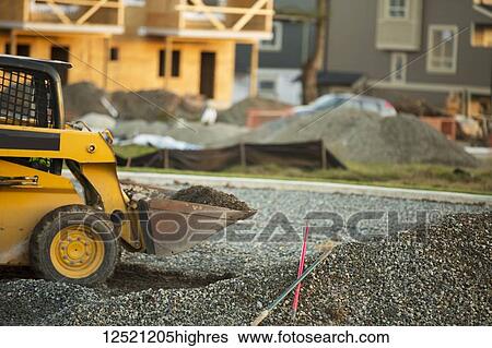 Small front end loader moving and placing gravel in a park area for new home construction; Langley, British Columbia, Canada View Large Photo Image Stock Photograph - Small front end loader moving and placing gravel in a park area for new home construction; Langley, British Columbia, Canada. Fotosearch