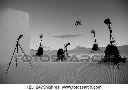 Stock Photograph - Spotlights on a professional snowboarder doing backside 180 at Snow Park; New Zealand. Fotosearch