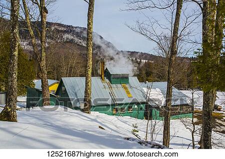 Stock Photograph - Steam billows from the top of a building in a rural area in winter; Potton, Quebec, Canada. Fotosearch
