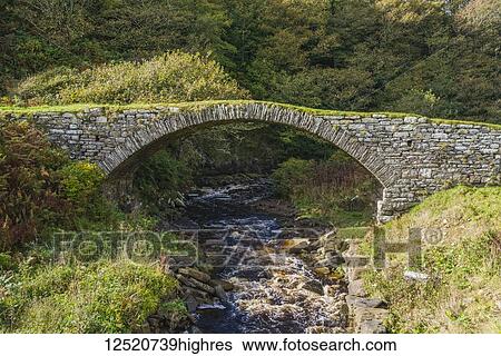 Stone arch bridge over a flowing stream; Dunbeath, Scotland View Large Photo Image Stock Photograph - Stone arch bridge over a flowing stream; Dunbeath, Scotland. Fotosearch