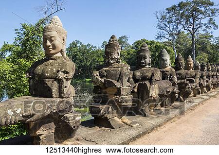 Stock Photograph - Stone figures on the causeway to the South Gate tower (Gopuram); Angkor Thom, Siem Reap, Cambodia. Fotosearch