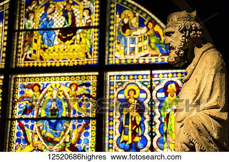 Stock Photograph - Stone statue with stain glass window in background in a church; Siena, Tuscany, Italy. Fotosearch