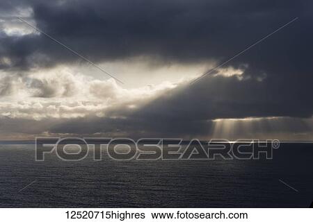 Stock Photograph - Sunlight breaks through the clouds off the coast of Oregon; Manzanita, Oregon, United States of America. Fotosearch