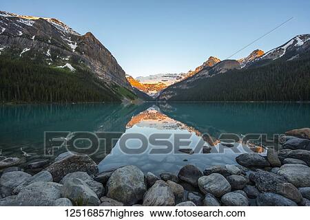 Stock Photograph - Sunrise at Lake Louise in the Rocky Mountains, Banff National Park; Lake Louise, Alberta, Canada. Fotosearch