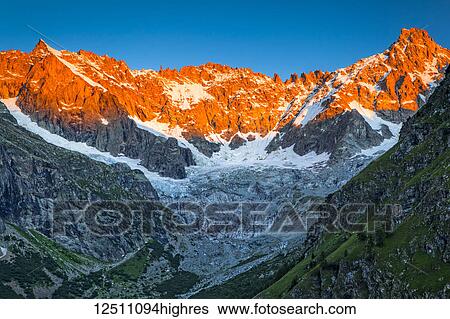 Sunrise glow on the peaks above l'A Neuve Glacier, viewed from La Fouly, Swiss Val Ferret, Alps; La Fouly, Val Ferret, Switzerland View Large Photo Image Stock Photograph - Sunrise glow on the peaks above l'A Neuve Glacier, viewed from La Fouly, Swiss Val Ferret, Alps; La Fouly, Val Ferret, Switzerland. Fotosearch