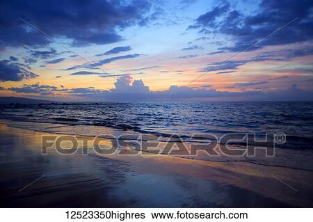 Stock Photograph - Sunset colours lighting oup clouds and ocean; Wailea, Maui, Hawaii, United States of America. Fotosearch