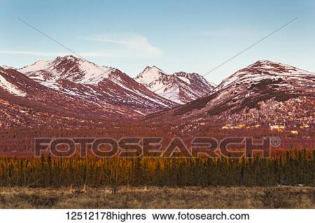 Stock Photograph - Sunset glow on Chugach Mountains and hillside houses, viewed from Anchorage, South-central Alaska in springtime; Anchorage, Alaska, United States of America. Fotosearch