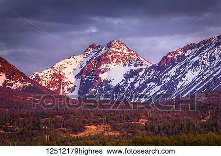 Stock Photograph - Sunset glows on Ptarmigan Peak in Chugach Mountains, South-central Alaska in spring; Alaska, United States of America. Fotosearch