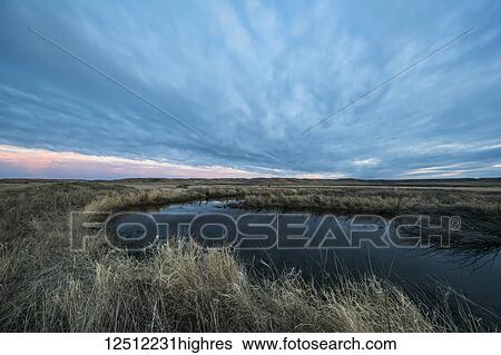 Sunset over a pond in Grasslands National Park; Saskatchewan, Canada View Large Photo Image Stock Photograph - Sunset over a pond in Grasslands National Park; Saskatchewan, Canada. Fotosearch