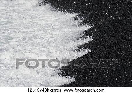 Stock Photograph - Surf breaks on a pebble beach near Yaquina Head on the coast of Oregon; Newport, Oregon, United States of America. Fotosearch