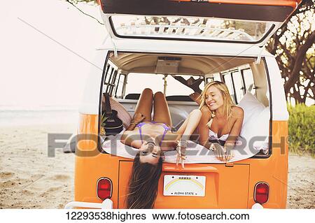 Surfer Girls Beach Lifestyle; Beautiful Surfer Girls Relaxing In The Back Of Classic Vintage Surf Van On The Beach At Sunset View Large Photo Image Stock Photograph - Surfer Girls Beach Lifestyle; Beautiful Surfer Girls Relaxing In The Back Of Classic Vintage Surf Van On The Beach At Sunset. Fotosearch