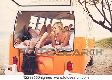 Surfer Girls Beach Lifestyle; Beautiful Surfer Girls Relaxing In The Back Of Classic Vintage Surf Van On The Beach At Sunset View Large Photo Image Stock Photograph - Surfer Girls Beach Lifestyle; Beautiful Surfer Girls Relaxing In The Back Of Classic Vintage Surf Van On The Beach At Sunset. Fotosearch