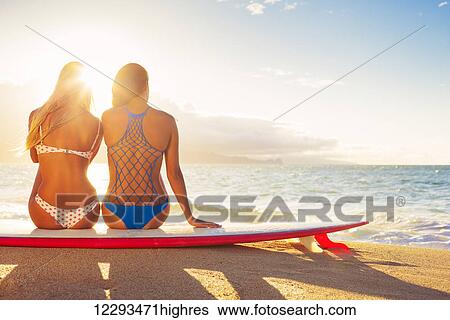Stock Photograph - Surfer Girls On The Beach At Sunset. Summer Outdoor Lifestyle. Best Friends Hanging Out On The Beach.. Fotosearch