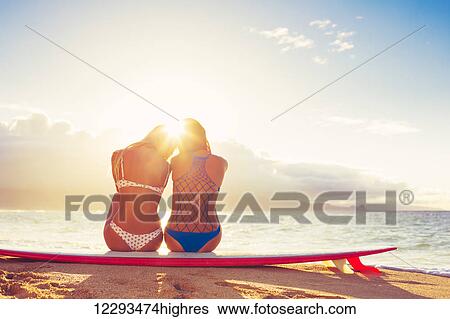 Surfer Girls On The Beach At Sunset. Summer Outdoor Lifestyle. Best Friends Hanging Out On The Beach. View Large Photo Image Stock Photograph - Surfer Girls On The Beach At Sunset. Summer Outdoor Lifestyle. Best Friends Hanging Out On The Beach.. Fotosearch