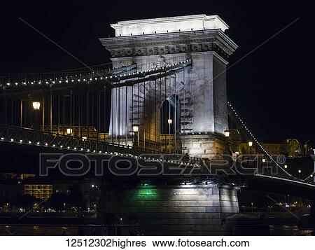 Stock Photograph - Szechenyi Chain Bridge illuminated at nighttime; Budapest, Budapest, Hungary. Fotosearch