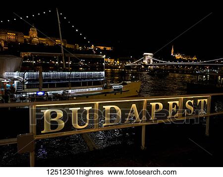 Szechenyi Chain Bridge over the Danube River and sign for Budapest illuminated at nighttime; Budapest, Budapest, Hungary View Large Photo Image Stock Photograph - Szechenyi Chain Bridge over the Danube River and sign for Budapest illuminated at nighttime; Budapest, Budapest, Hungary. Fotosearch