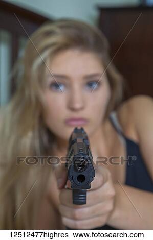 Teenage girl with blond hair pointing a gun at the camera; Connecticut, United States of America View Large Photo Image Stock Photograph - Teenage girl with blond hair pointing a gun at the camera; Connecticut, United States of America. Fotosearch