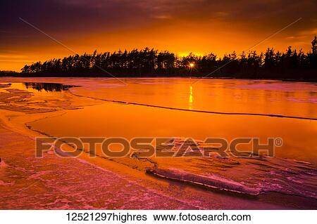Stock Photograph - Thawing ice at sunset on Rocky Lake; Waverley, Nova Scotia, Canada. Fotosearch