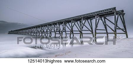 Stock Photograph - The disused Steetley Pier in the 'blue hour' built to serve the former Hartlepool Magnesia Works which has now been demolished; Hartlepool, County Durham, England. Fotosearch