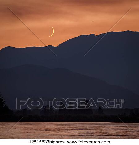 The moon and Venus in an orange sky over the silhouetted mountains, Fraser Valley; Vancouver, British Columbia, Canada View Large Photo Image Stock Photograph - The moon and Venus in an orange sky over the silhouetted mountains, Fraser Valley; Vancouver, British Columbia, Canada. Fotosearch