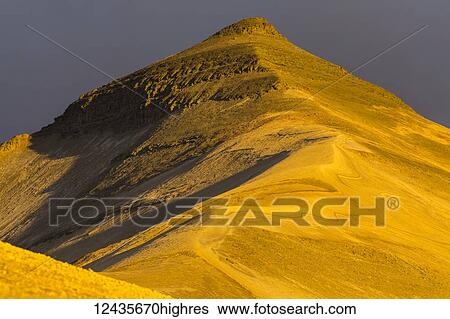 Stock Photograph - The peak of Baked Mountain glows at sunset in the Valley of Ten Thousand Smokes in Katmai National Park; Alaska, United States of America. Fotosearch