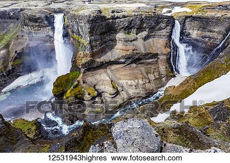 The stunning earthy colors and rock formations along with unmelted snow resting in the bottom of the Haifoss valley among two waterfalls. Natural beauty in one of Iceland's great hiking viewpoints; Iceland View Large Photo Image Stock Photograph - The stunning earthy colors and rock formations along with unmelted snow resting in the bottom of the Haifoss valley among two waterfalls. Natural beauty in one of Iceland's great hiking viewpoints; Iceland. Fotosearch