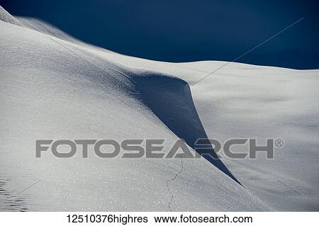 Stock Photograph - The surface of the snow sparking in the sunlight with blue sky over the horizon; Haines, Alaska, United States of America. Fotosearch
