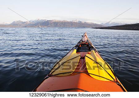 Stock Photograph - The tip of a canoe pointing towards the Kenai mountains, Kachemak Bay State Park; Alaska, United States of America. Fotosearch