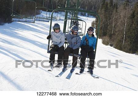 Stock Photo - Three woman ride the chair lift at Hilltop Ski Area in Anchorage, Alaska. Fotosearch