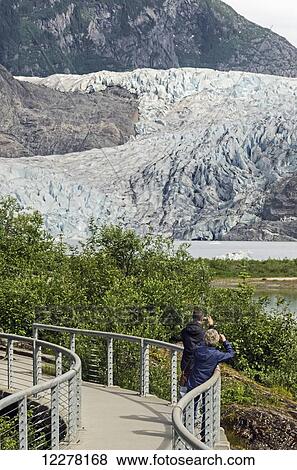 Tourists photographing Mendenhall Glacier in Tongass National Forest, Southeast Alaska, summer View Large Photo Image Stock Photo - Tourists photographing Mendenhall Glacier in Tongass National Forest, Southeast Alaska, summer. Fotosearch