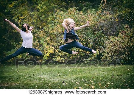 Two Girlfriends Leaping Through The Air Try Doing A Martial Arts Kick Move For Fun Outdoors In A Park On A Fall Evening; Edmonton, Alberta, Canada View Large Photo Image Stock Photograph - Two Girlfriends Leaping Through The Air Try Doing A Martial Arts Kick Move For Fun Outdoors In A Park On A Fall Evening; Edmonton, Alberta, Canada. Fotosearch