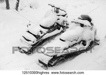 Stock Photograph - Two snowmobiles covered in snow, Grand Targhee Resort; Wyoming, United States of America. Fotosearch