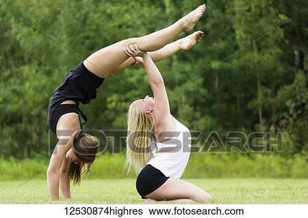 Two Teenage Gymnists Practicing Their Routines Outdoors In A Park And Doing Handstand Partner Balances; Edmonton, Alberta, Canada View Large Photo Image Stock Photograph - Two Teenage Gymnists Practicing Their Routines Outdoors In A Park And Doing Handstand Partner Balances; Edmonton, Alberta, Canada. Fotosearch