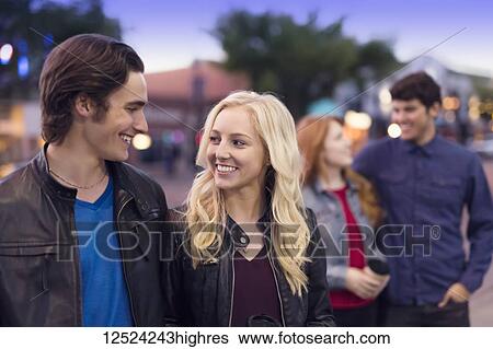 Two young couples walk down a popular street at dusk; Edmonton, Alberta, Canada View Large Photo Image Stock Photograph - Two young couples walk down a popular street at dusk; Edmonton, Alberta, Canada. Fotosearch